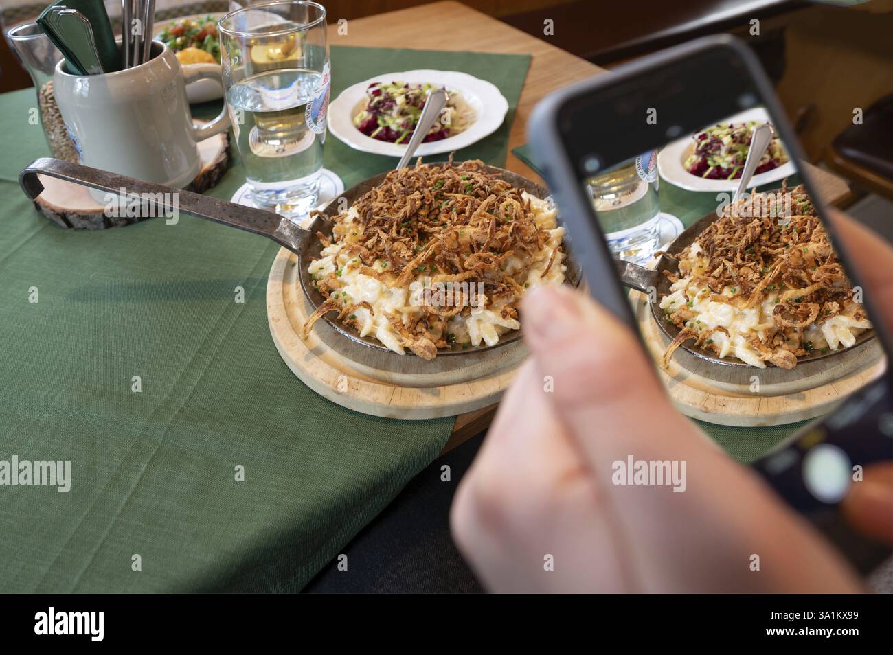 Invité prenant des photos de sa nourriture avec son téléphone portable, fromage spaetzle dans une casserole, Bavière, Allemagne, Europe Banque D'Images