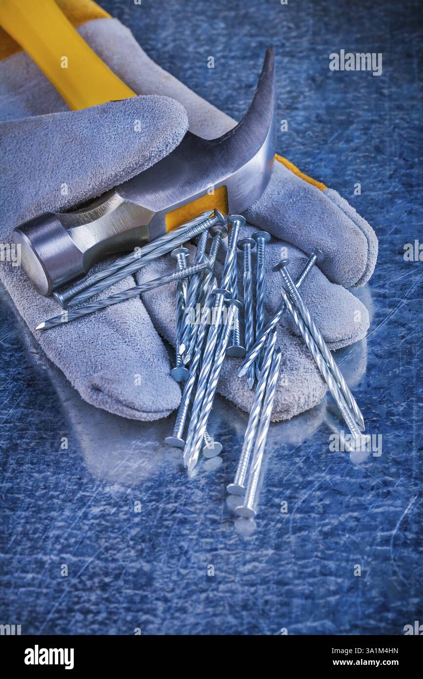 Gant de protection variété de clous de construction et marteau à griffes sur le concept d'entretien de surface métallique rayée Banque D'Images