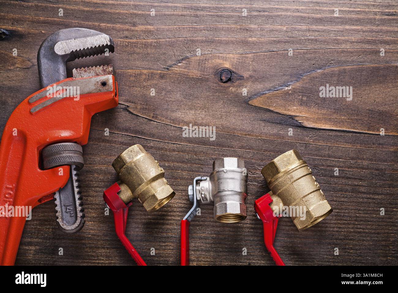 Plombiers avec poignées rouges et clé à singe sur panneau de bois vintage avec concept de construction copyspace Banque D'Images
