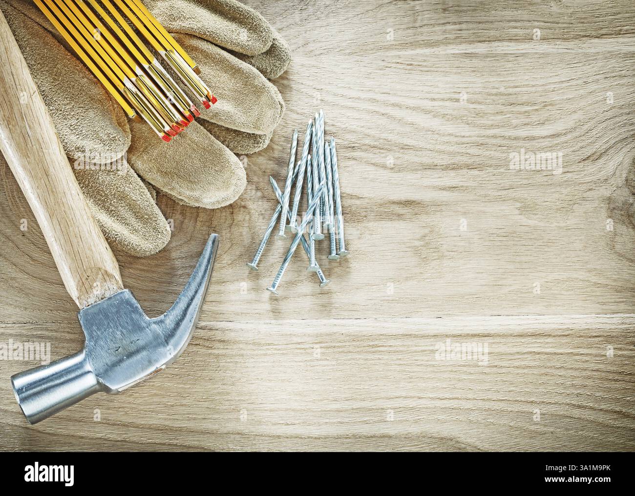 Gants de protection clous de marteau de mètre en bois sur le concept de construction d'espace de copie de panneau de bois Banque D'Images