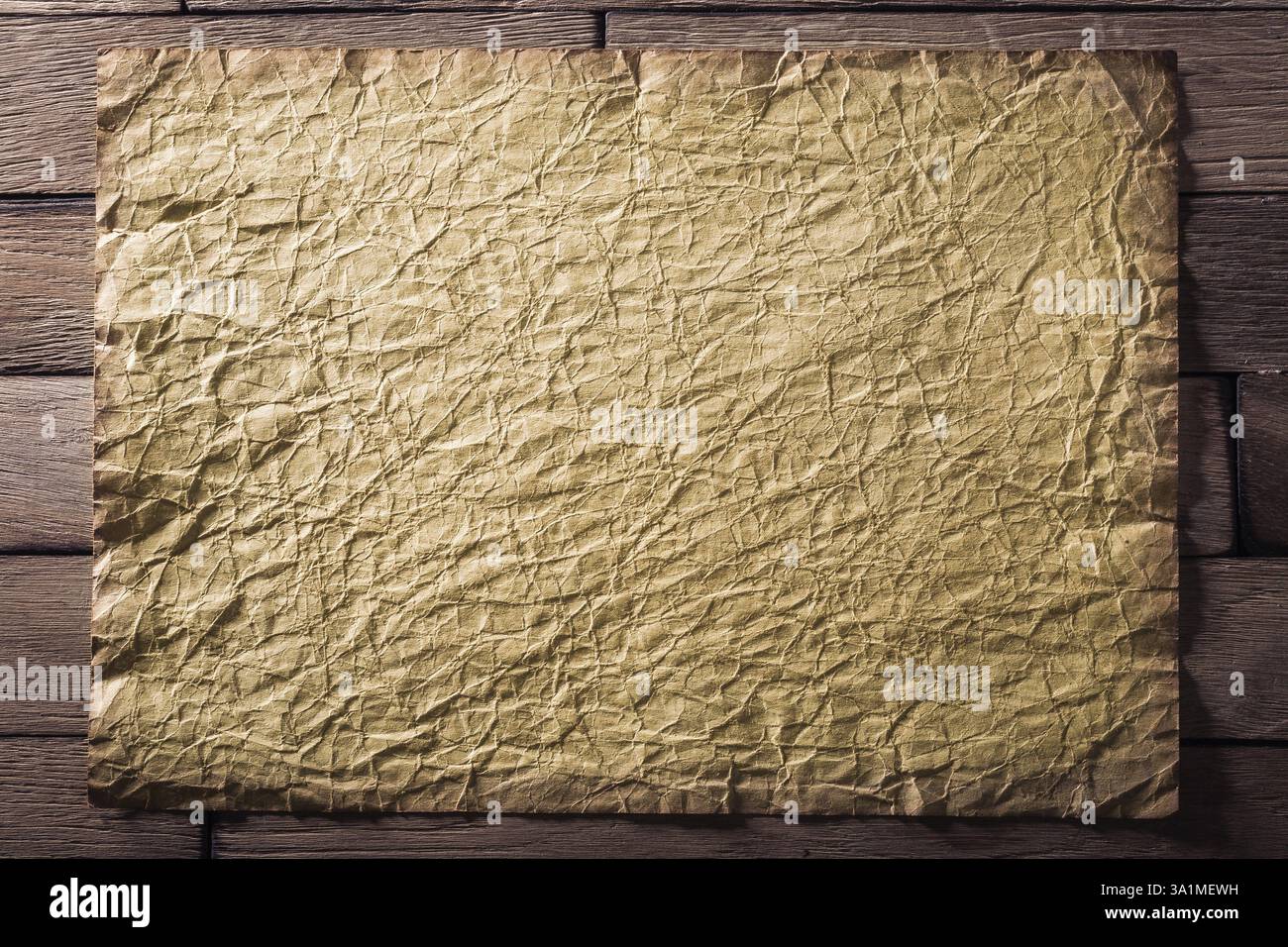 Vieille feuille de papier froissée sur des planches de bois. CR2 Banque D'Images