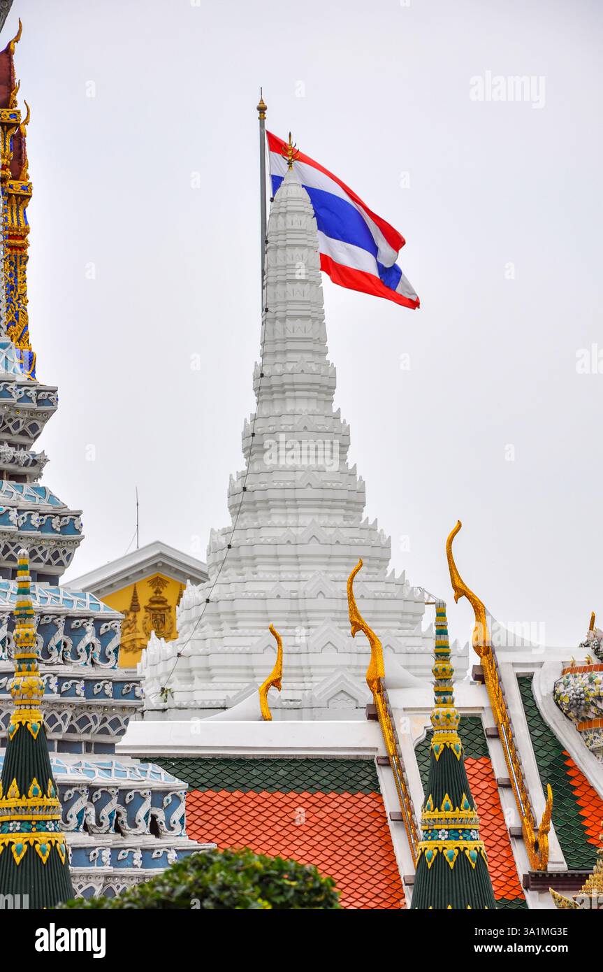 Bangkok, Thaïlande - 4 mai 2009 : le drapeau national thaïlandais s'élève au-dessus de l'architecture ornée et dorée de Wat Phra Kaew, symbole de fierté culturelle et intric Banque D'Images
