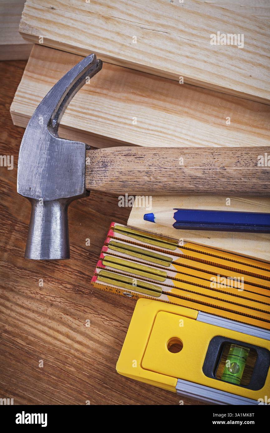 Mètre en bois de crayon et briques niveau de construction marteau à griffe sur panneau de bois vintage close up concept de maintenance d'image Banque D'Images