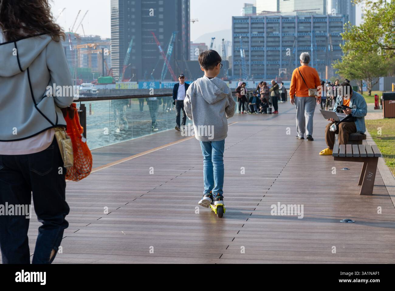 Hong Kong. Chine- 02.15.2025. Les résidents locaux apprécient les activités récréatives sur la promenade de Kwun Tong par une belle journée ensoleillée. Banque D'Images