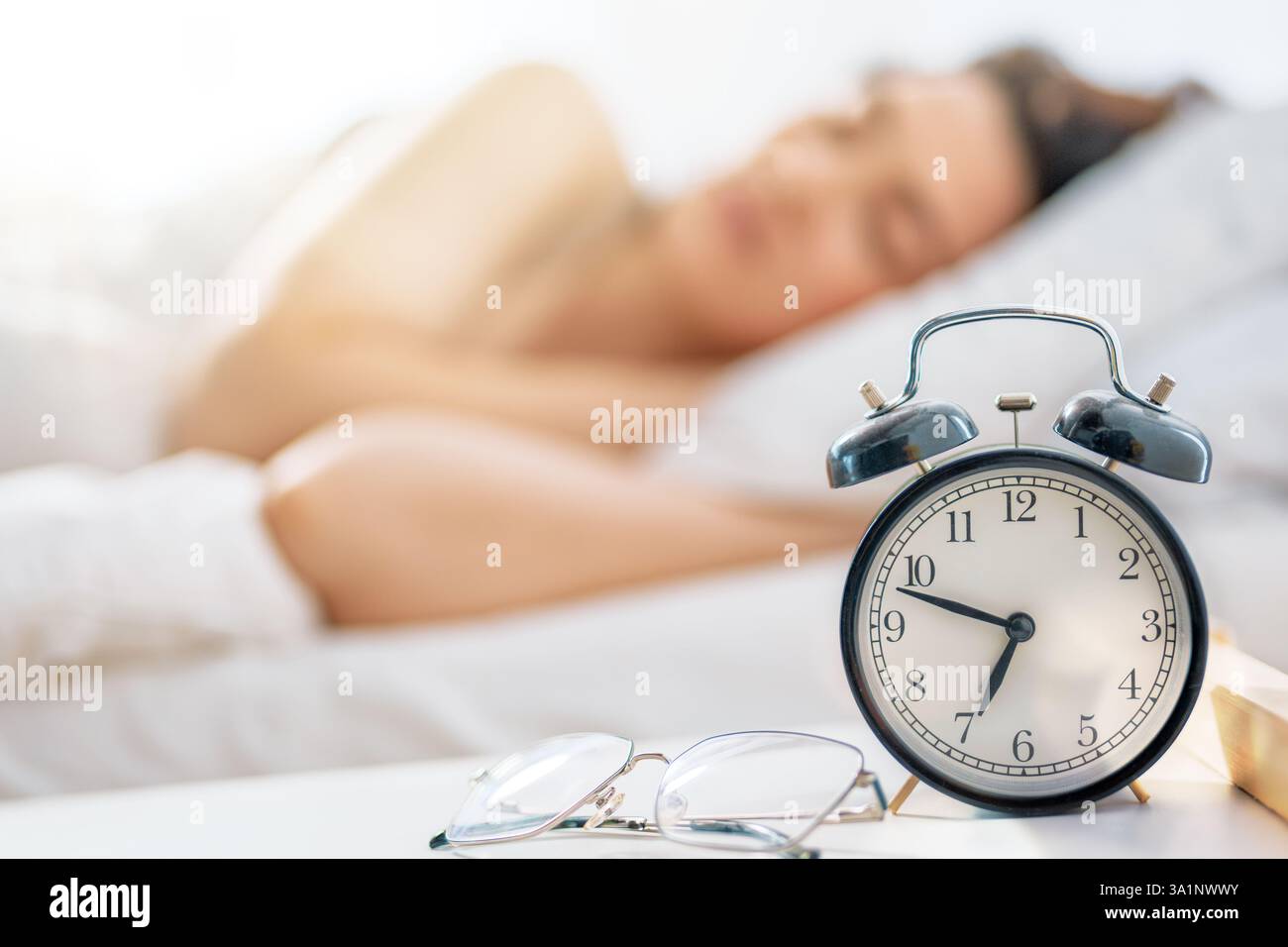 Une belle jeune femme dort dans la chambre à coucher à la maison. Banque D'Images