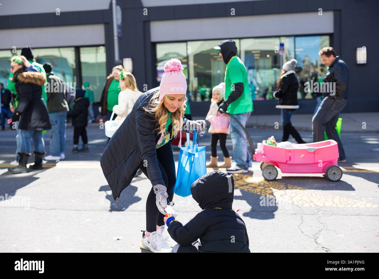 Scranton, PA - 8 mars 2025 : pendant la défilé de Patrick, les gens marchent et distribuent des bonbons et des souvenirs. Banque D'Images