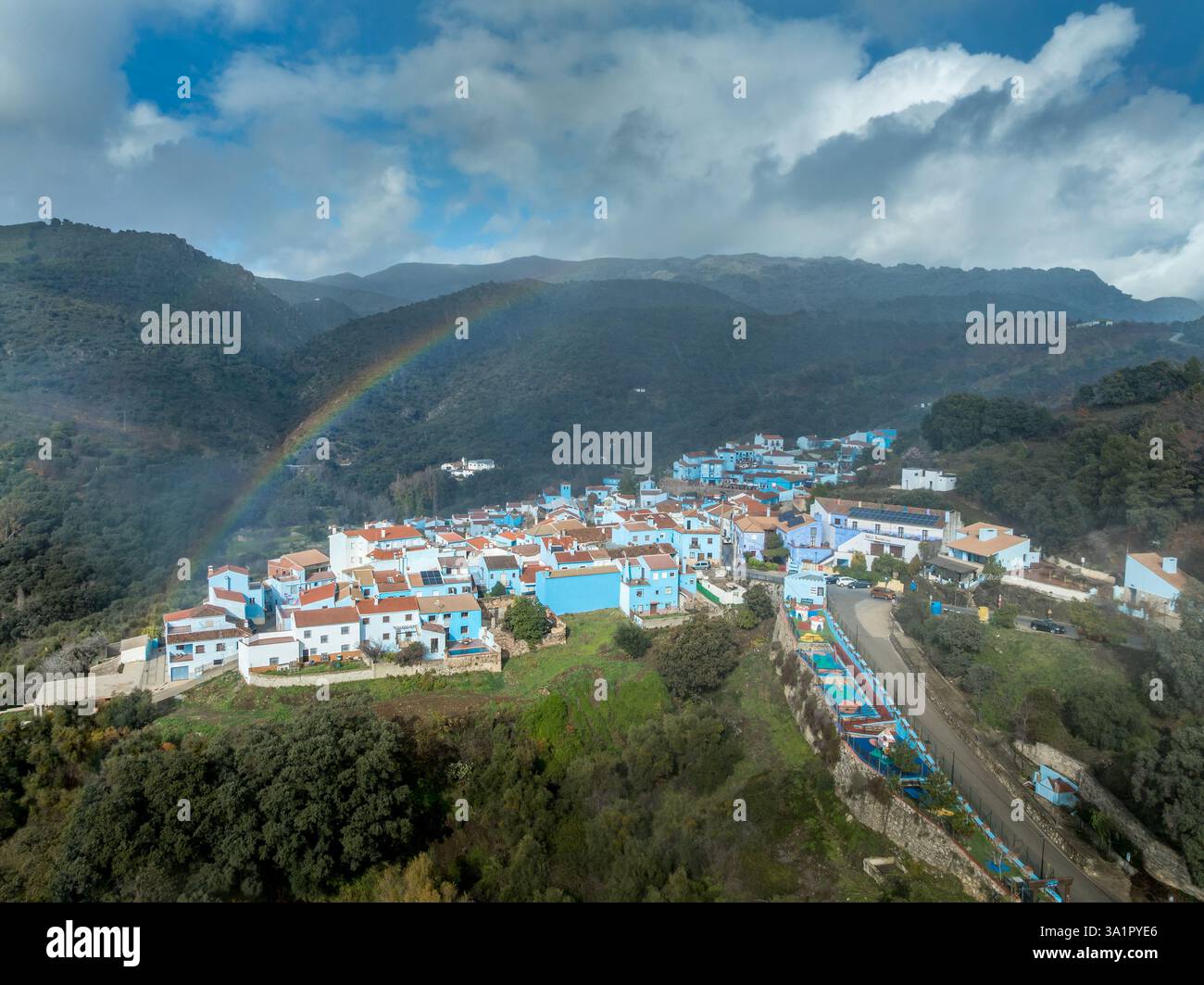 Vue aérienne du village Schtroumpf Juzcar maisons peintes avec une teinte bleue arc-en-ciel coloré dans le ciel Banque D'Images