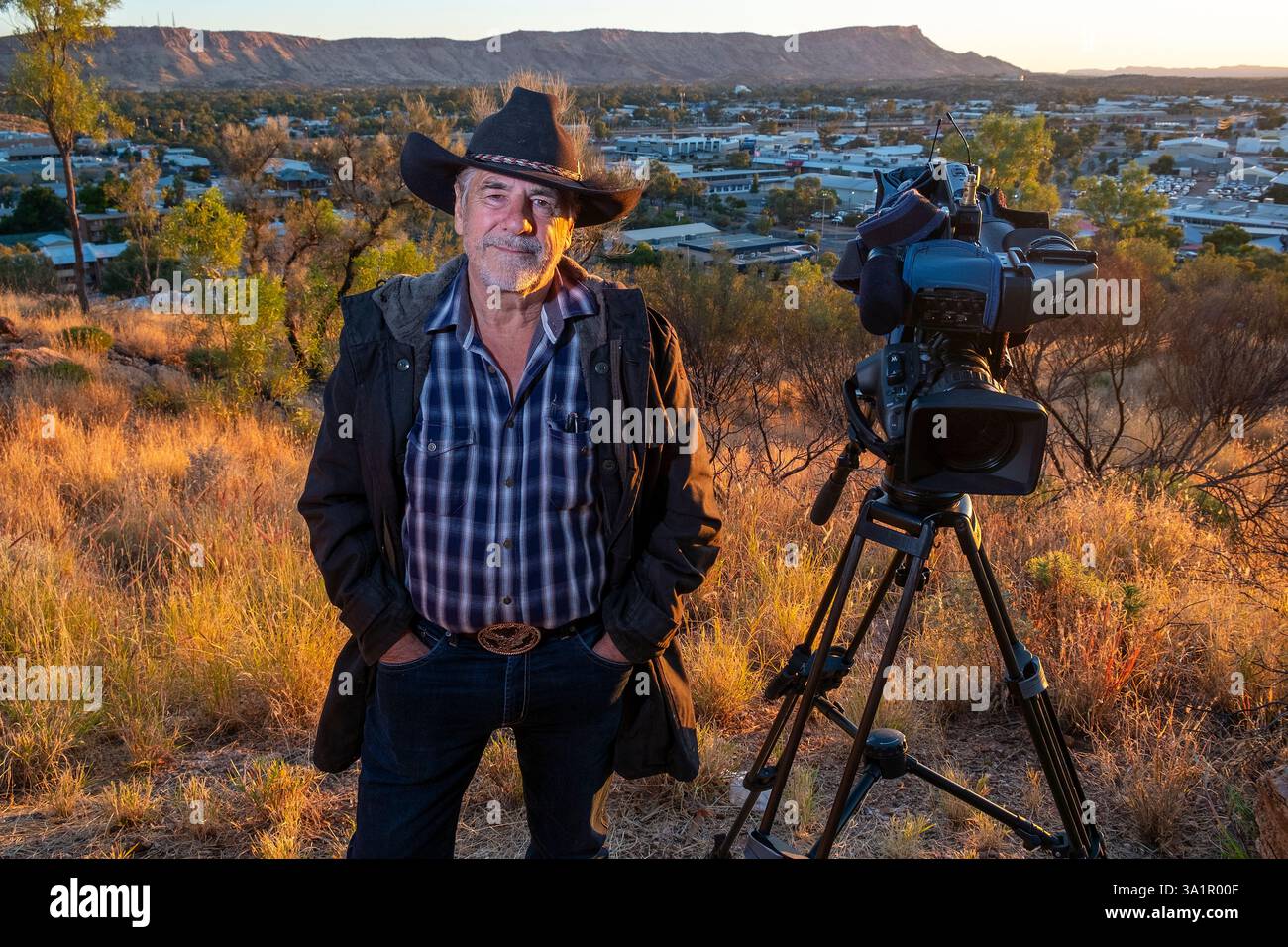 Le caméraman de télévision Grenville Turner, qui est basé à Alice Springs photographié avec une toile de fond de la ville depuis Anzac Hill. Banque D'Images