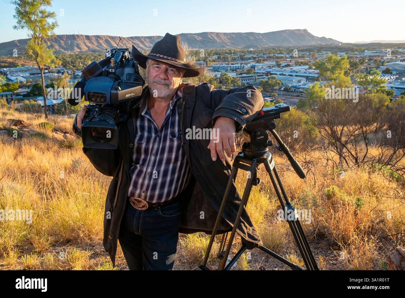 Le caméraman de télévision Grenville Turner, qui est basé à Alice Springs photographié avec une toile de fond de la ville depuis Anzac Hill. Banque D'Images
