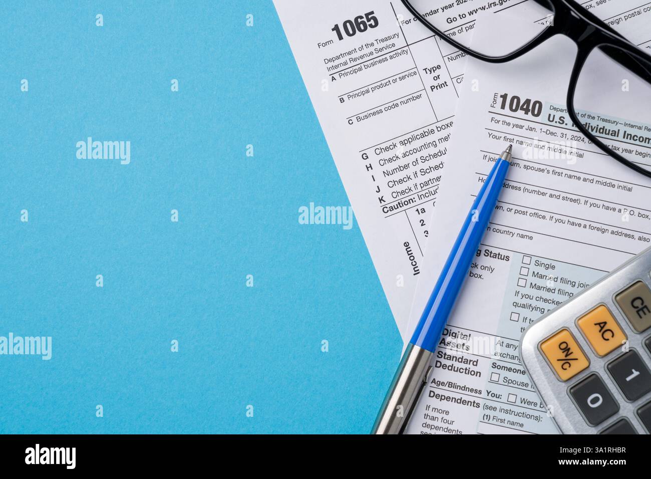 Vue de dessus des formulaires d'impôt, calculatrice et stylo sur la table bleue Banque D'Images