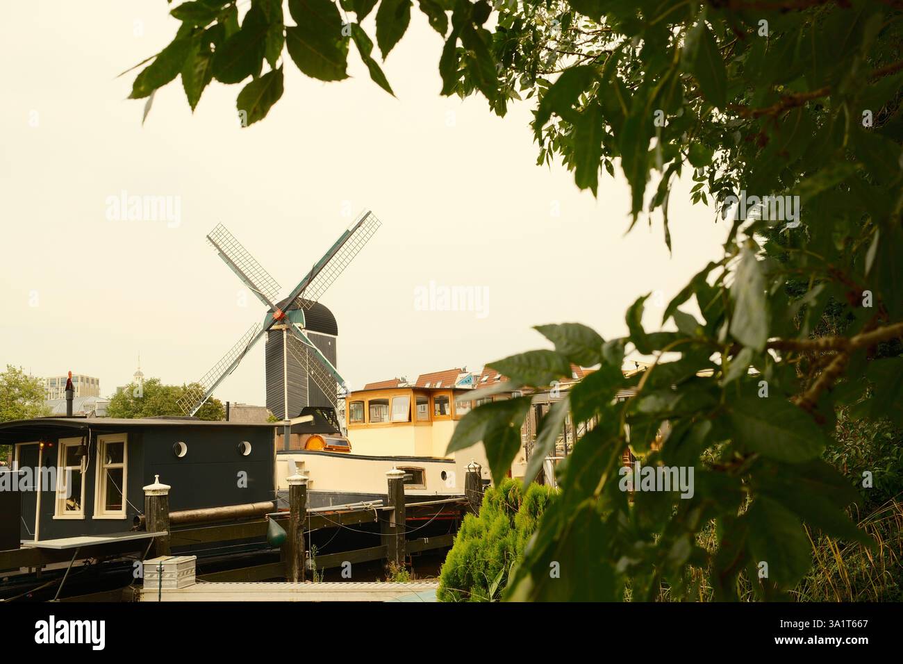 Le moulin à vent hollandais traditionnel se dresse au-dessus des péniches sur le canal Banque D'Images
