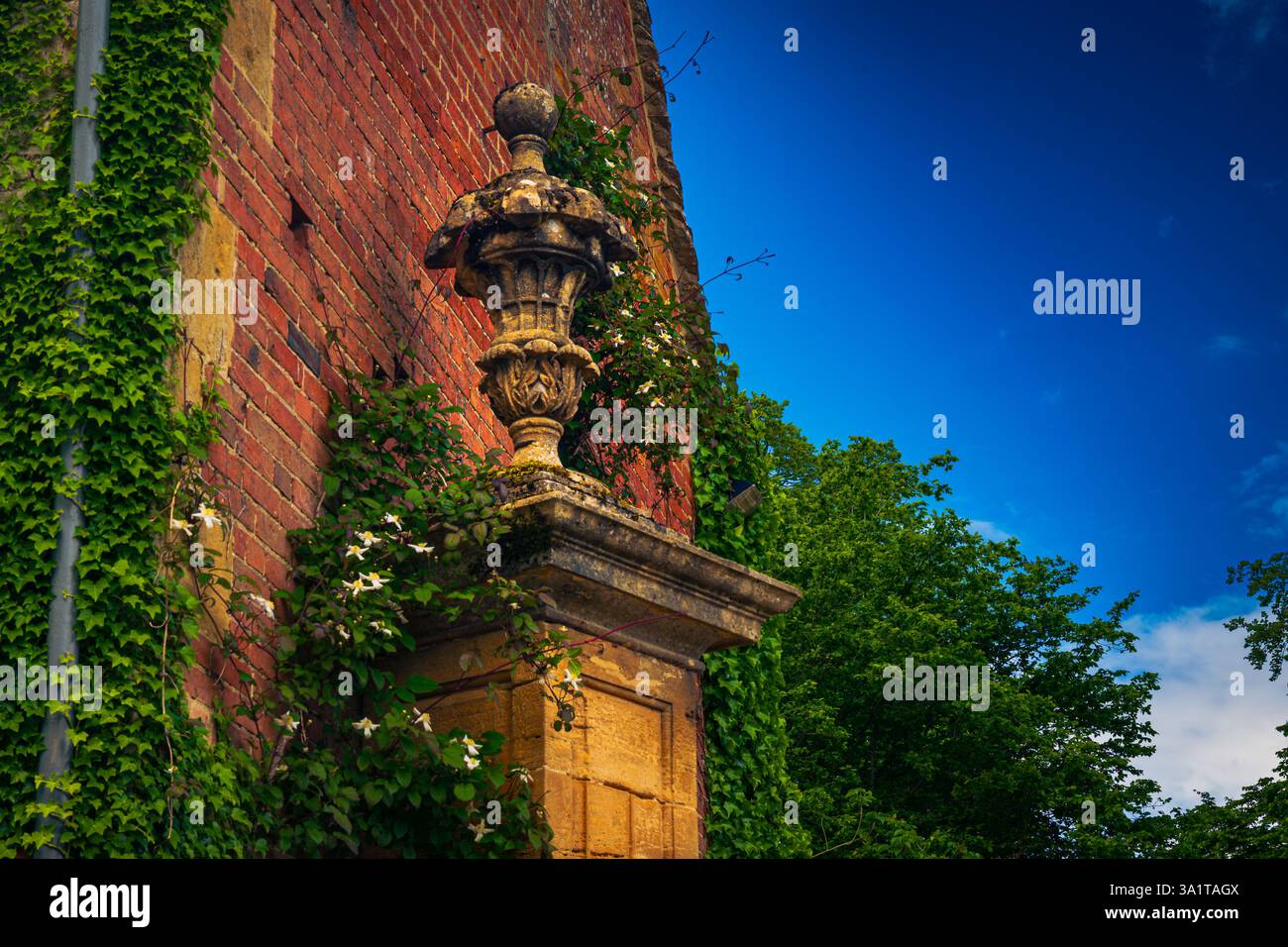 Une statue au sommet de la porte d'entrée d'un manoir dans les Cotswolds, Gloucestershire, Royaume-Uni Banque D'Images