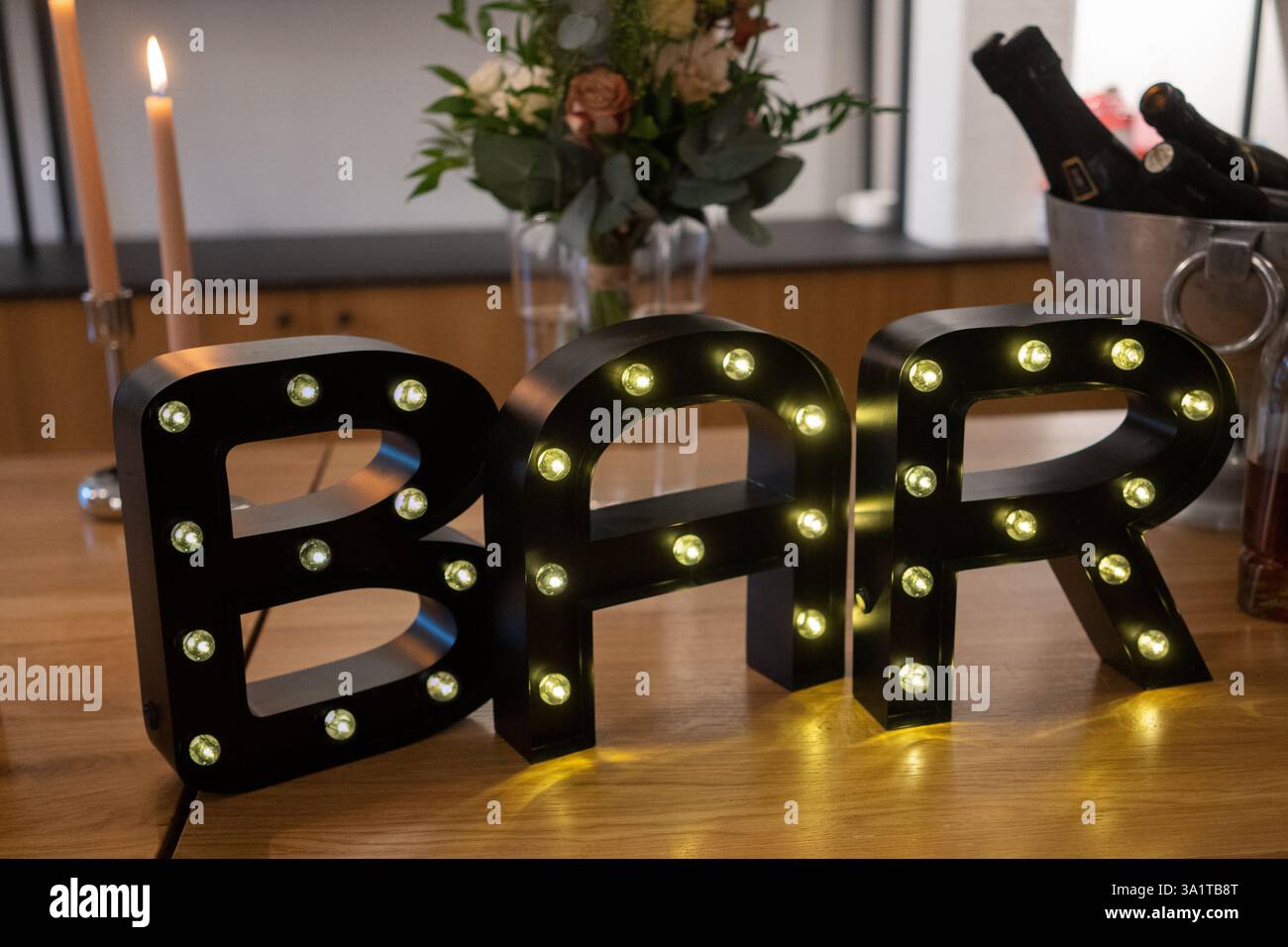 Lettres noires B, A et R avec des lumières LED sur la table en bois. La BARRE LED allume les lettres. Banque D'Images