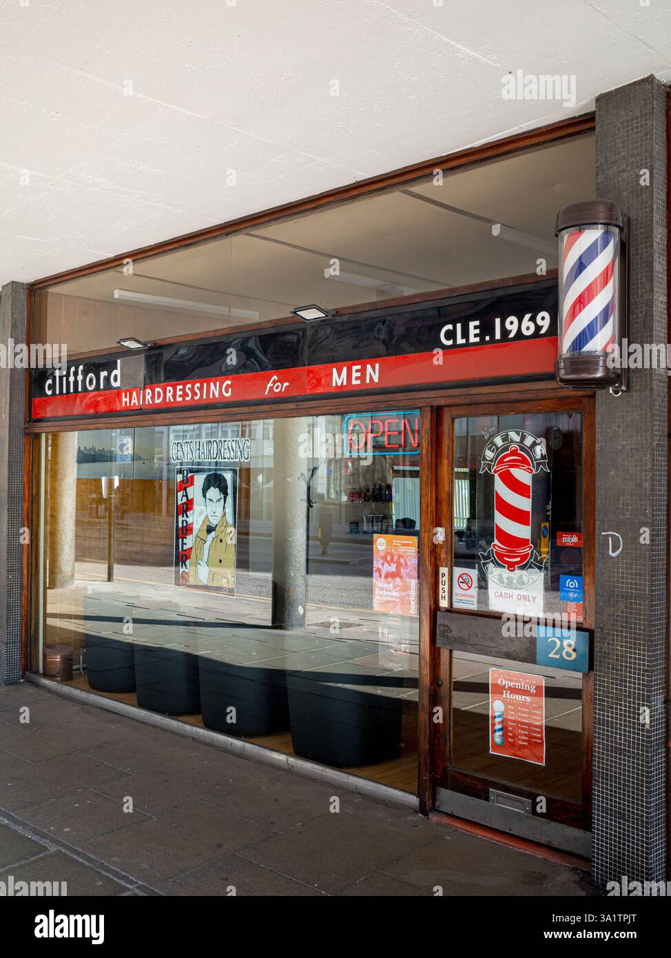 Coiffeurs Cliffords The City, Golden Lane Estate London. Les barbiers des années 1960 font leurs courses près du domaine Barbican dans le centre de Londres. Créé en 1969. Banque D'Images