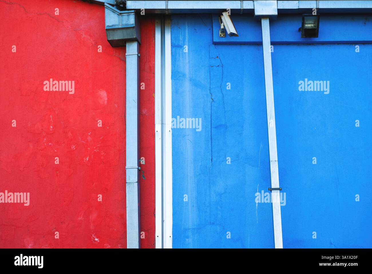 Fond abstrait urbain, texture murale rouge et bleue avec gouttières de pluie Banque D'Images