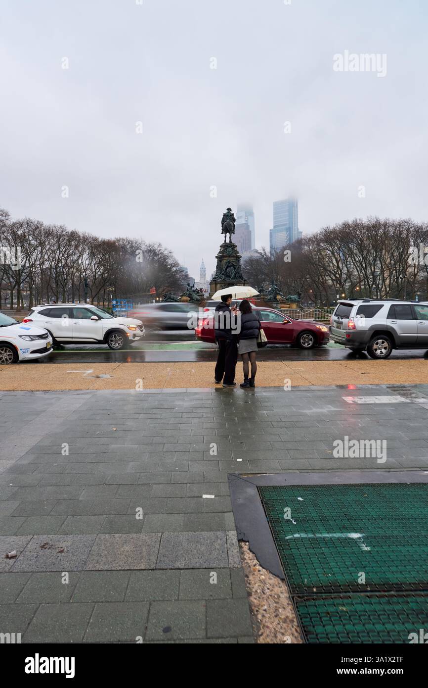 Un couple sous la pluie face à la fontaine Washington Monument Banque D'Images
