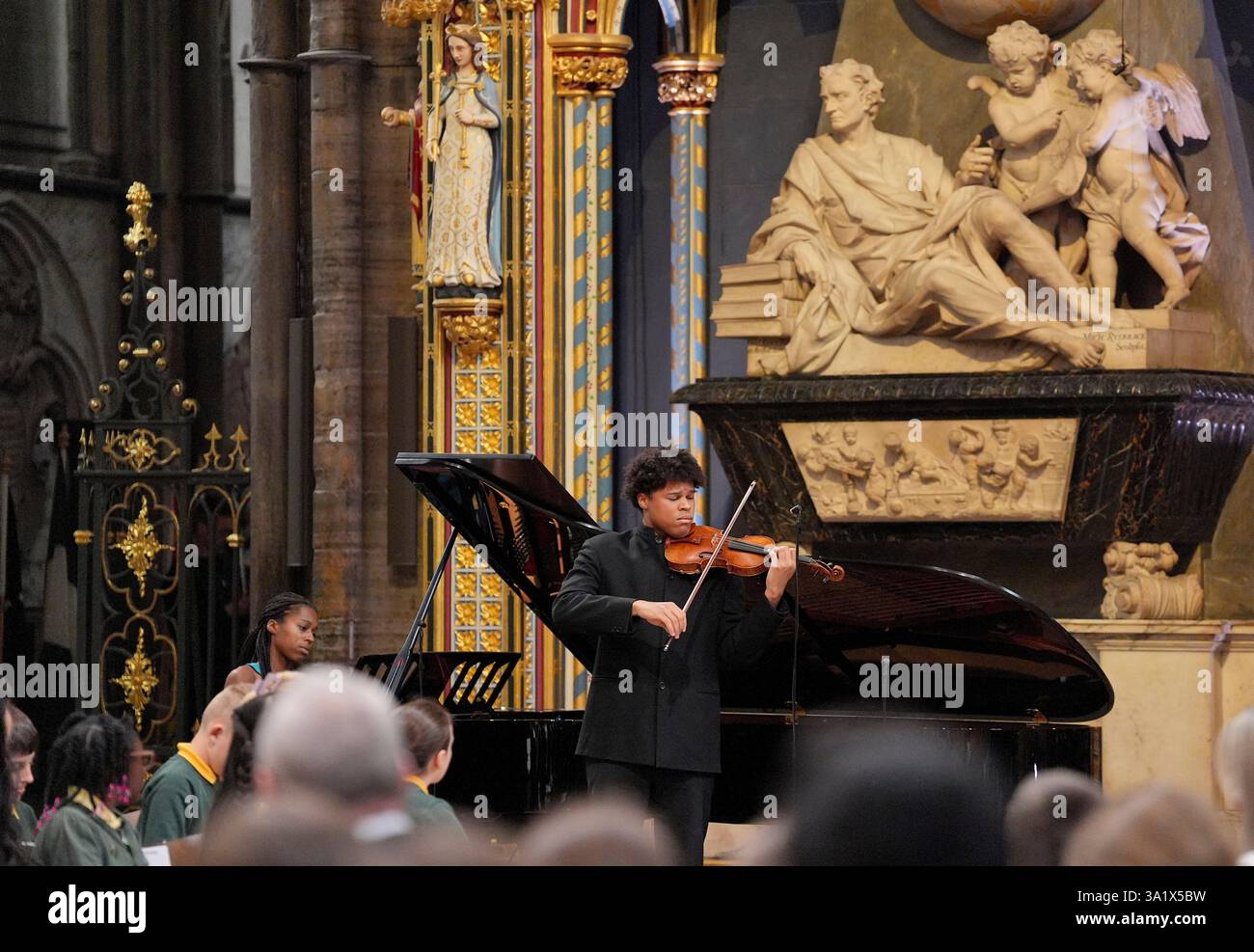 Braimah Kanneh-Mason, background left, playing the piano, and Jeneba Kanneh-Mason, playing the violin perform, during the annual Commonwealth Day Service of Celebration at Westminster Abbey, in London, Monday March 10, 2025. (Yui Mok/Pool Photo via AP) Banque D'Images