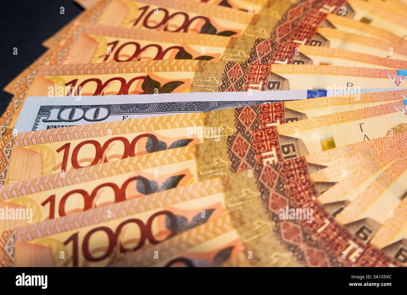 100 dollars parmi 1000 billets de tenge. Papier-monnaie provenant de la circulation Banque D'Images 100 dollars parmi 1000 billets de tenge. Papier-monnaie provenant de la circulation Banque D'Images