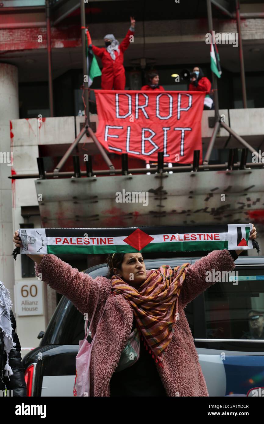 Londres, Angleterre, Royaume-Uni. 10 mars 2025. Un partisan tient une écharpe palestinienne tendue alors que des militants de Palestine action occupent le toit pendant la manifestation. Palestine action cible les bureaux d'assurance Allianz à Gracechurch Street à Londres dans la City de Londres, en lâchant une bannière disant˜Drop Elbit' et en pulvérisant de la peinture rouge sur l'extérieur du bâtiment. L'action de la Palestine vise Allianz parce qu'ils assurent et investissent dans la société israélienne d'armement Elbit Systems, ils ciblent de nombreuses sociétés partenaires d'Elbit Systems avec une action directe persistante pour essayer de rendre cela impossible pour le crédit Banque D'Images