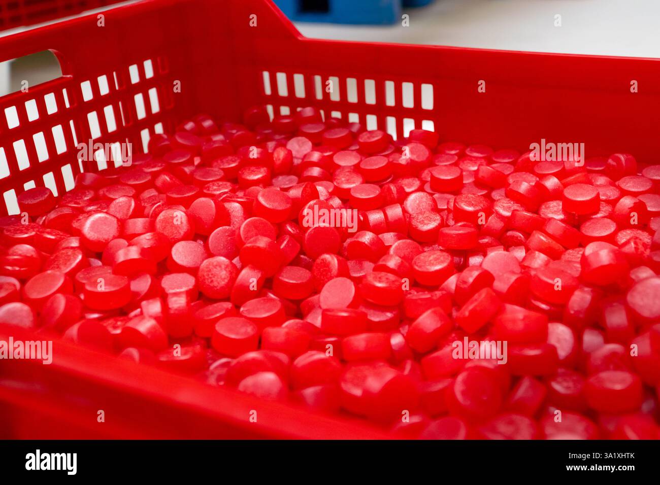 Boîte avec des bonbons gommeux rouges brillants éclatants stockés à l'usine après la production industrielle Banque D'Images