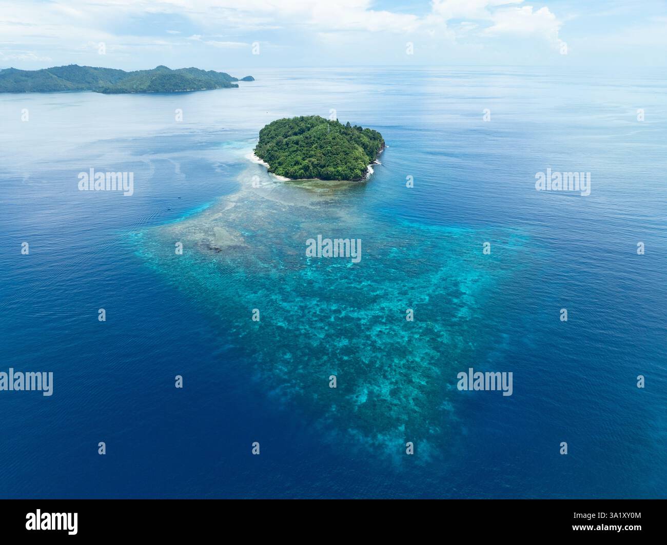 Une belle île est entourée par un récif corallien sain au large de la côte de Sulawesi Nord, Indonésie. Cette zone abrite une biodiversité marine élevée. Banque D'Images