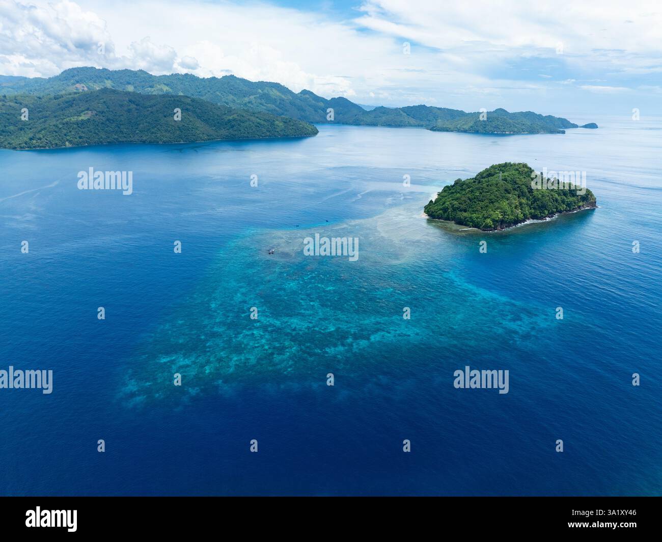 Une belle île est entourée par un récif corallien sain au large de la côte de Sulawesi Nord, Indonésie. Cette zone abrite une biodiversité marine élevée. Banque D'Images