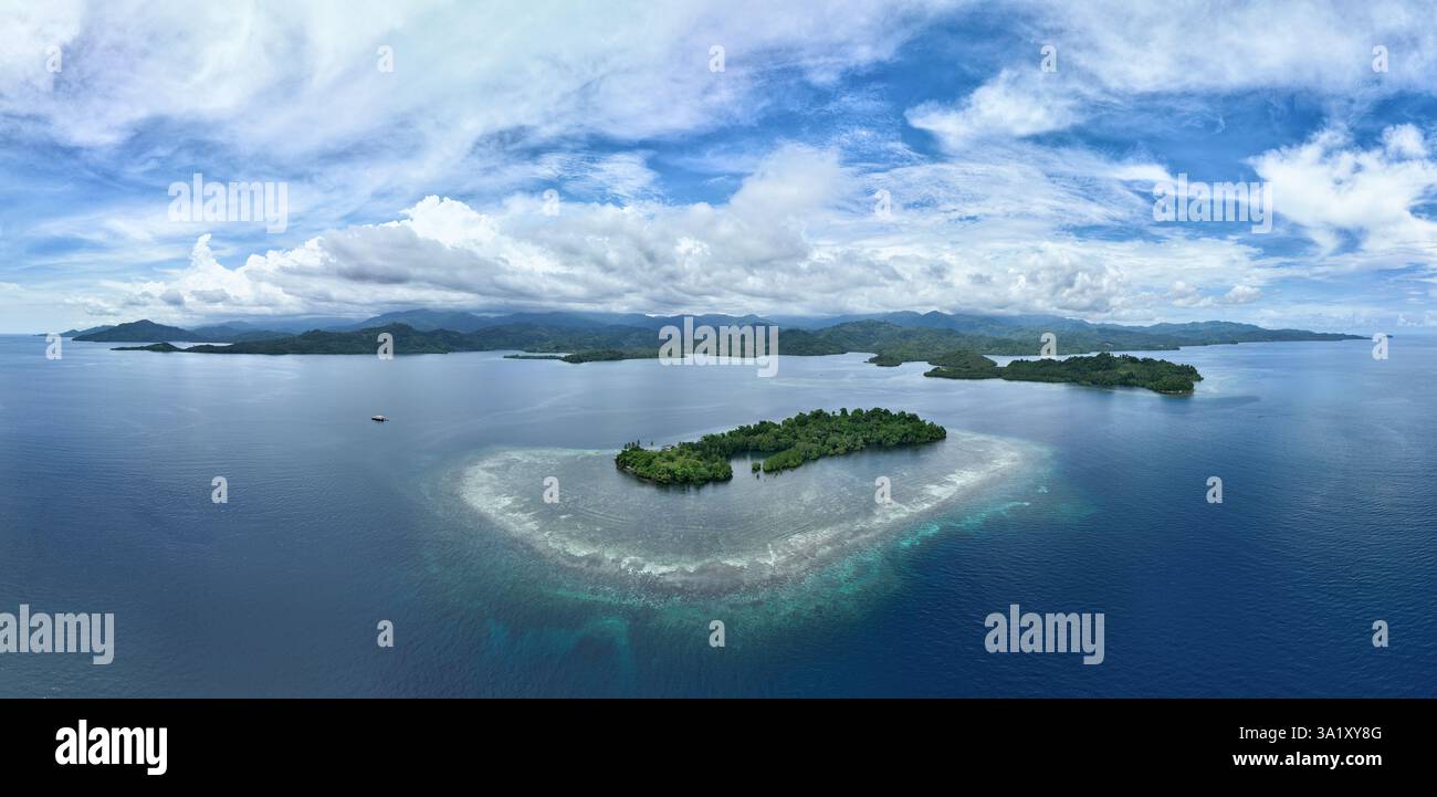 Une belle île est entourée par un récif corallien sain au large de la côte de Sulawesi Nord, Indonésie. Cette zone abrite une biodiversité marine élevée. Banque D'Images