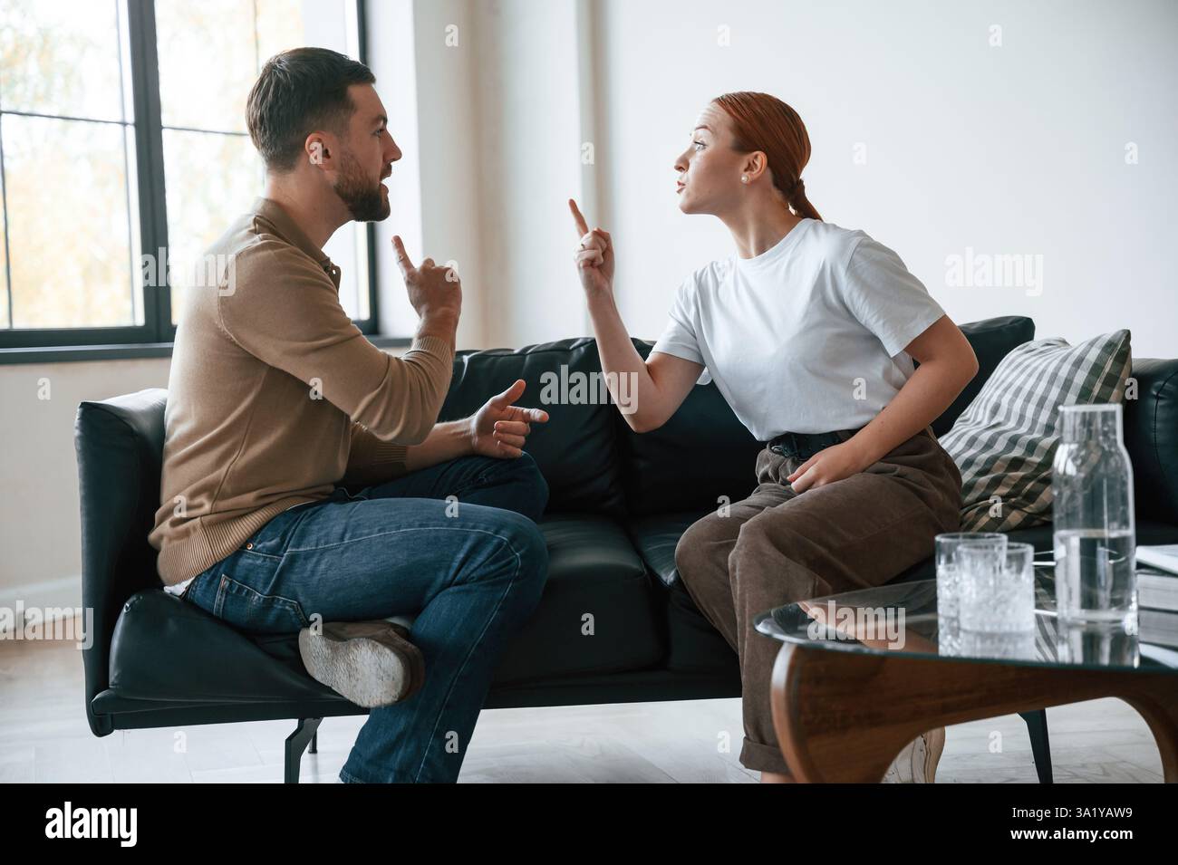 Vue latérale du couple qui se disputent. Assis sur le canapé. Banque D'Images