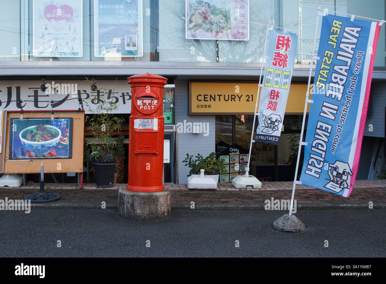 Une boîte aux lettres japonaise et des signes pour une société immobilière fournissant des services en anglais près du camp Zama US Army base, Zama, Japon. Banque D'Images