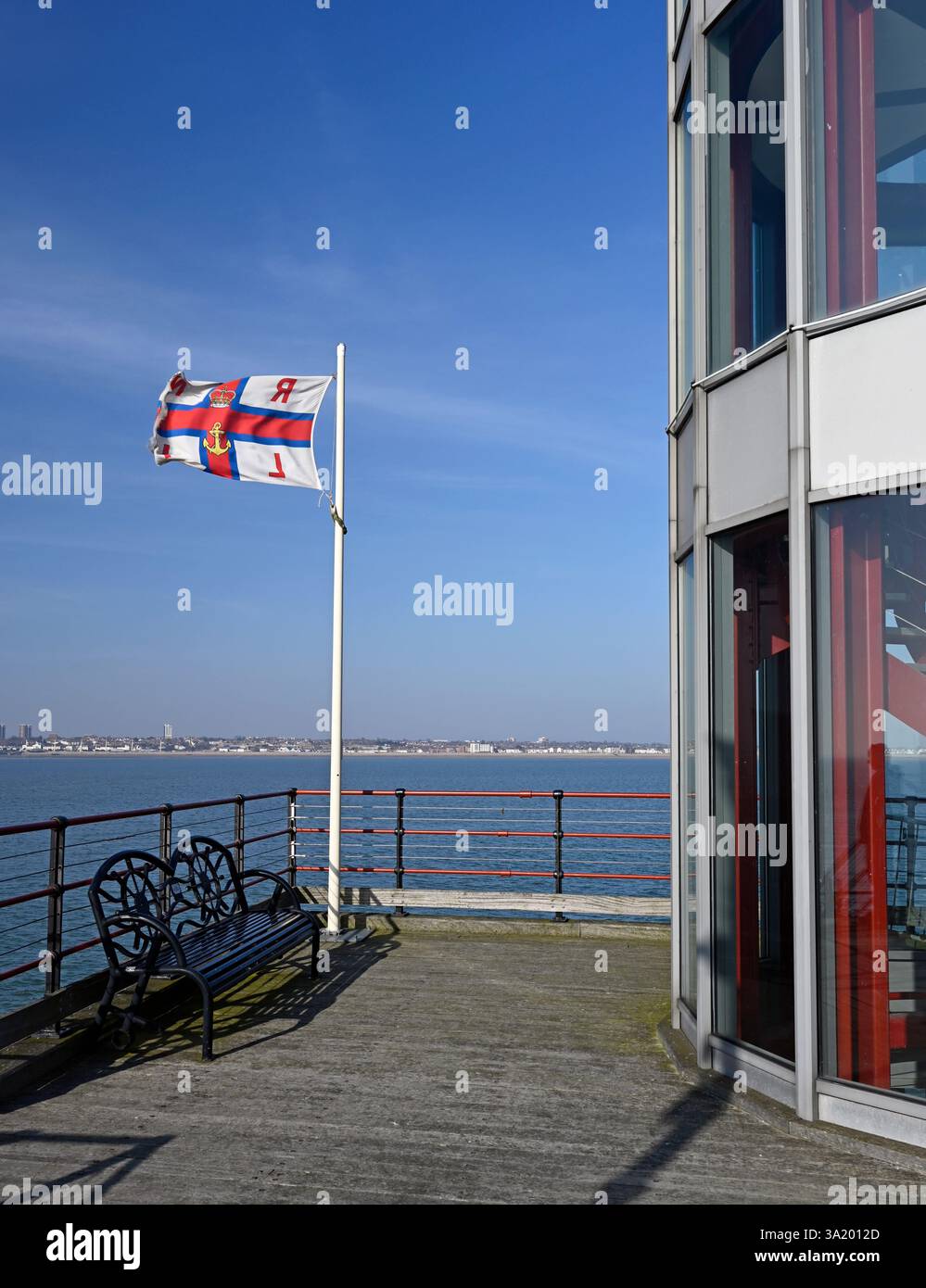 Un drapeau RNLI sur un poteau à côté de la tour de la station de sauvetage à Pier Head sur le plus long quai de plaisance du monde, Southend on Sea. ROYAUME-UNI Banque D'Images