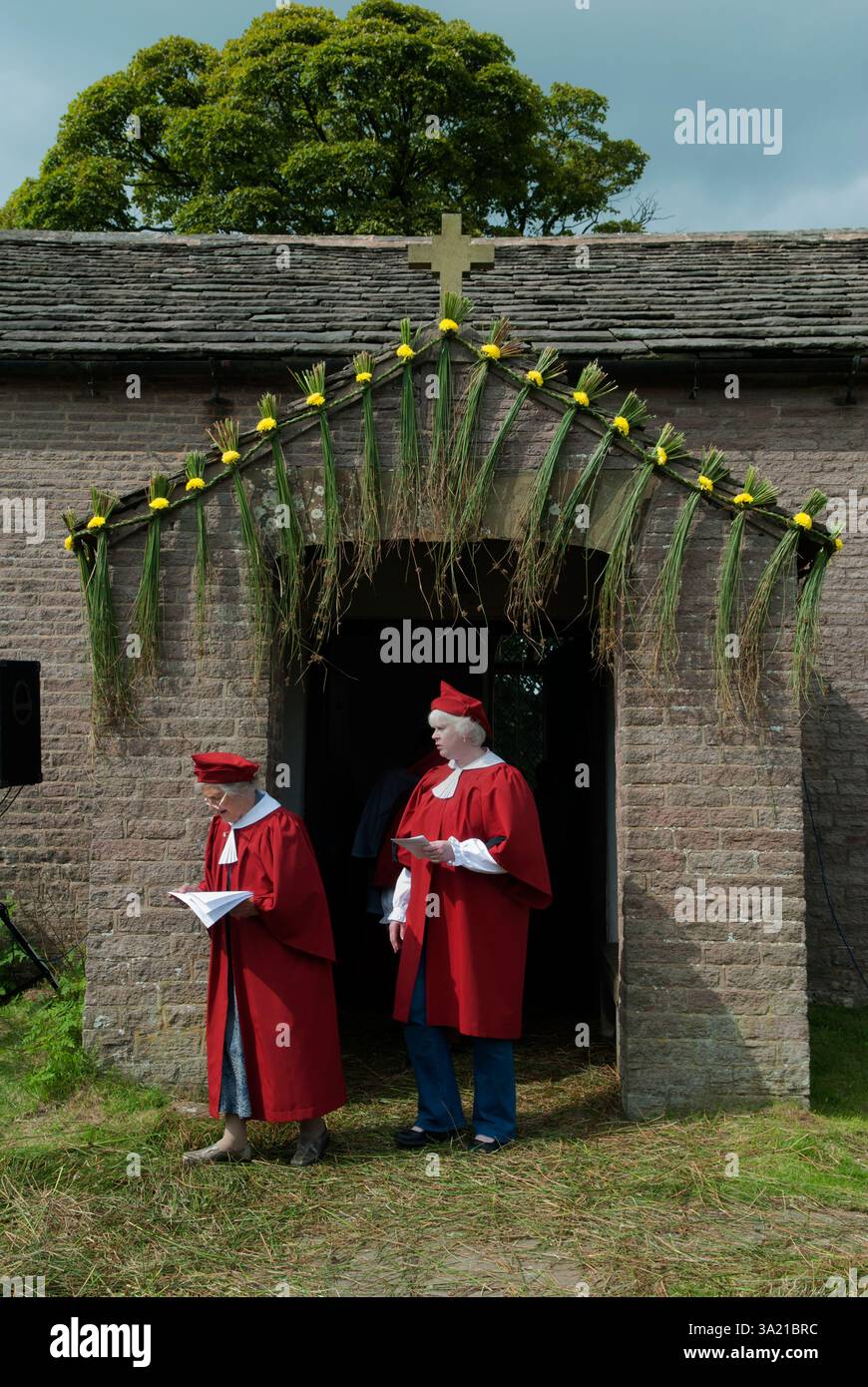 Église St Stephens - Chapelle forestière Rushbear service d'église en plein air. Les membres de la chorale vêtus de rouge sont assis dans le cimetière parmi les pierres tombales lors de la célébration annuelle du Rush Bearing. Macclesfield Forest, Macclesfield, Cheshire, Angleterre 13 août 2017 2010s UK HOMER SYKES Banque D'Images