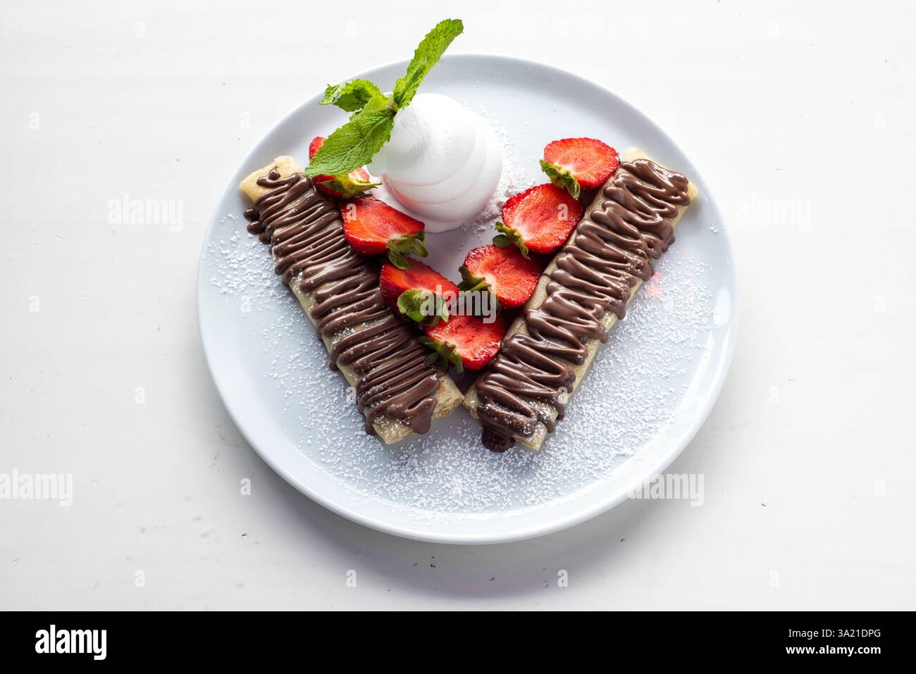 Délicieuse crêpe à la sauce au chocolat servie avec des fraises et de la crème Banque D'Images