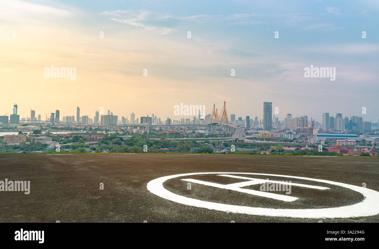 Héliport en asphalte avec paysage urbain durable. Plate-forme d'atterrissage pour hélicoptère surélevée située dans le centre-ville contemporain. Le transport aérien relie Banque D'Images