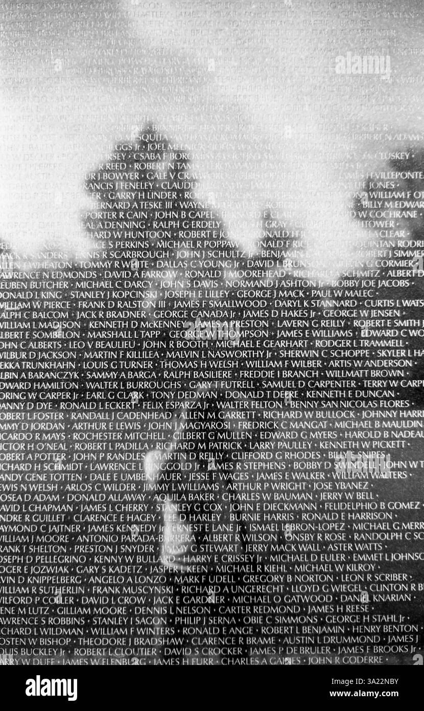 Mémorial des vétérans du Vietnam sur une photographie en noir et blanc montrant l'un des panneaux de granit avec les noms de dizaines de soldats tombés photographe visible dans la surface brillante semblable à un miroir de l'un des 144 panneaux. Banque D'Images