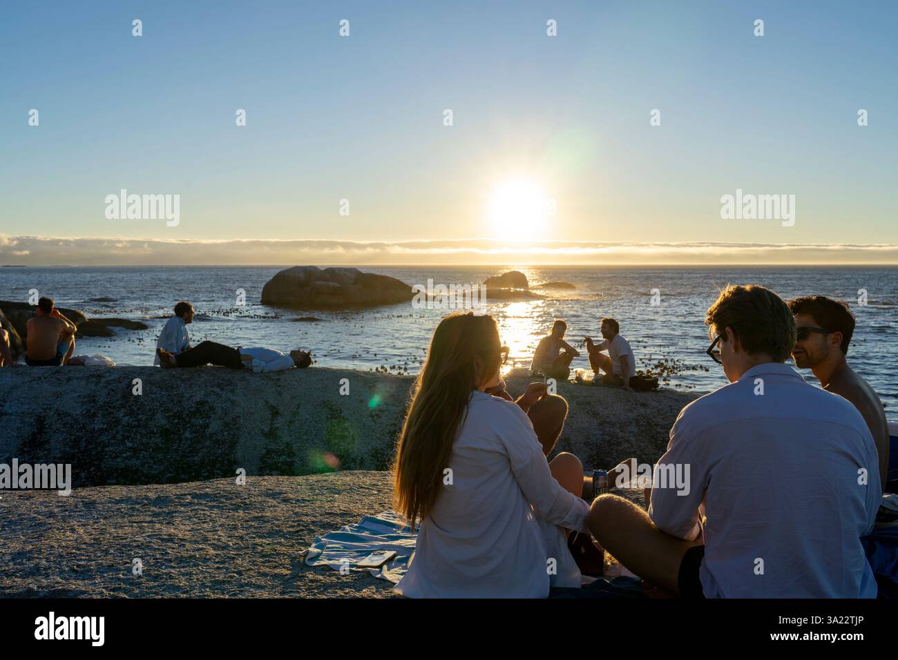 Les gens attendent le coucher du soleil sur la plage de Bakoven - Cape Town, Afrique du Sud Banque D'Images