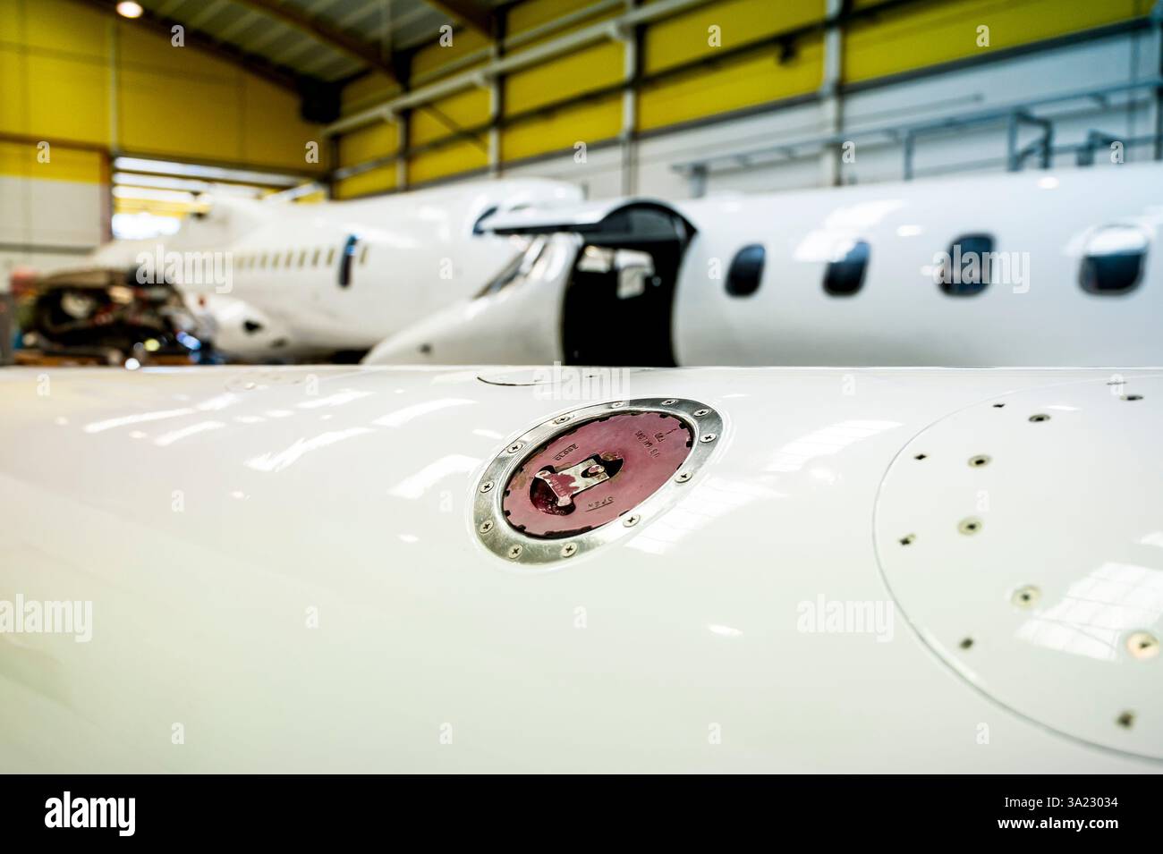 Un avion blanc avec un bouchon de réservoir de paraffine rouge sur le côté. Banque D'Images