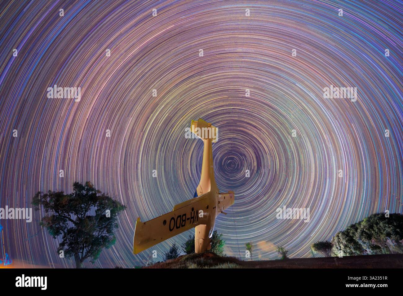 traînées d'étoiles la nuit avec avion jaune Banque D'Images