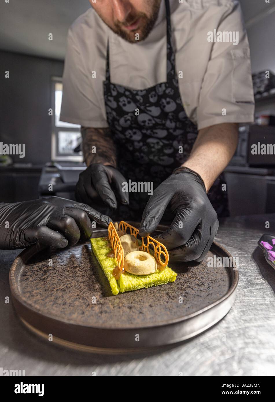 Chef garnissant un dessert vert citron avec une décoration caramel Banque D'Images