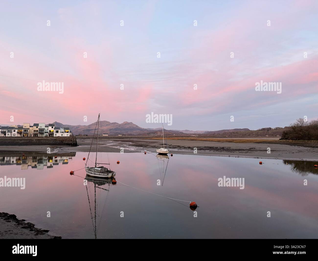 Rose ciel au coucher du soleil, bateaux amarrés sur l'estuaire, Porthmadog, pays de Galles - Image de stock capturée avec un smartphone