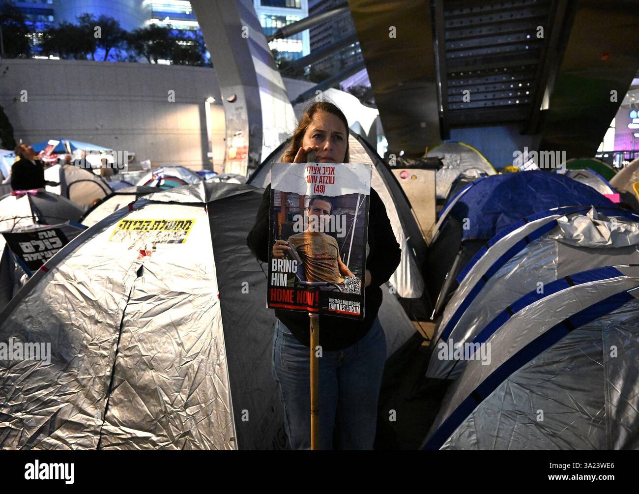 Tel Aviv, États-Unis. 11 mars 2025. Une femme tient une affiche d’un otage dans un campement de tente de protestation devant le ministère israélien de la Défense à tel Aviv, appelant le premier ministre israélien Benjamin Netanyahu à entrer dans la deuxième phase de l’accord de cessez-le-feu sur les otages et la libération des otages détenus par le Hamas à Gaza le mardi 11 mars 2025. Photo de Debbie Hill/ crédit : UPI/Alamy Live News Banque D'Images