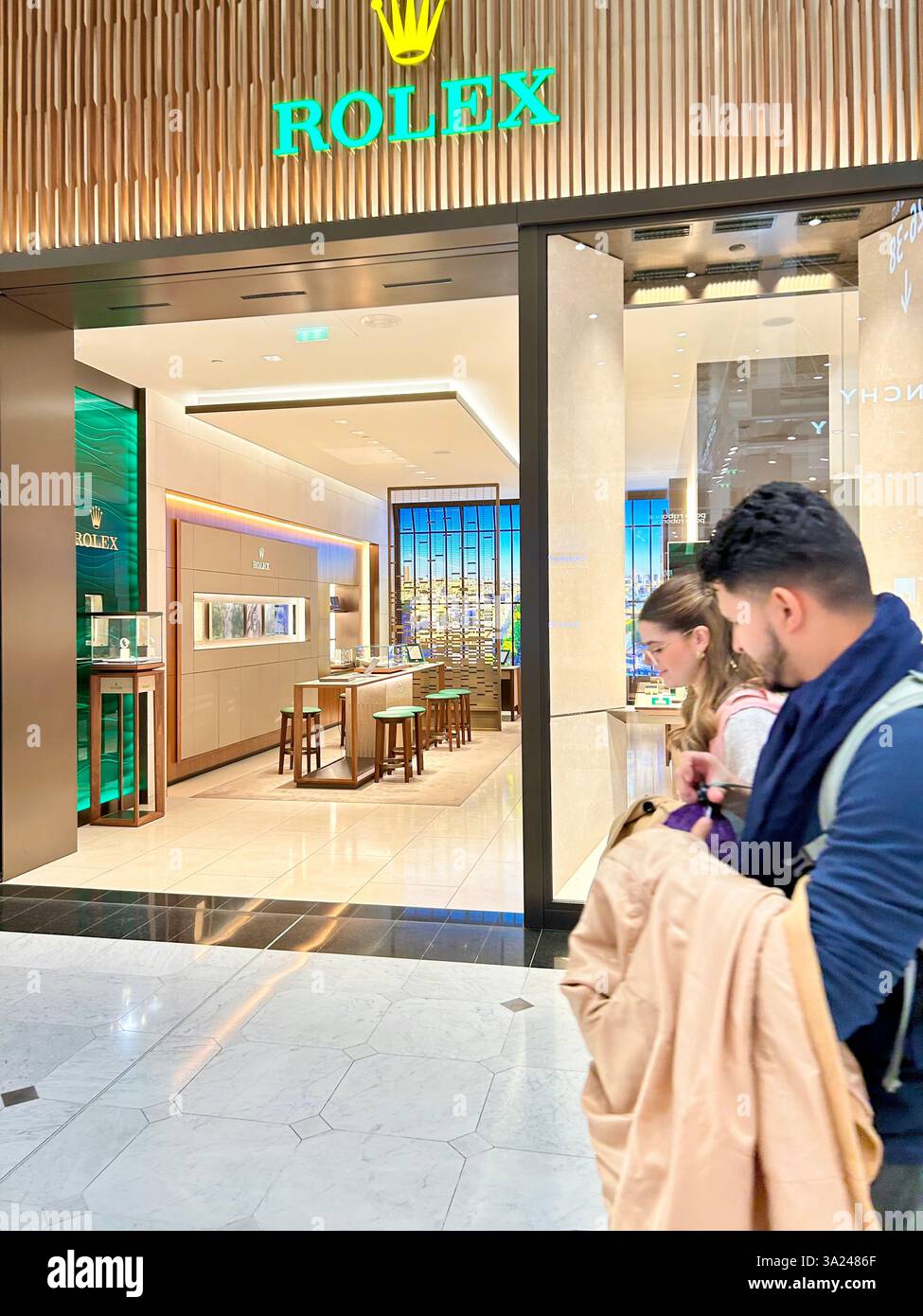 Roissy Charles de Gaulle, Aéroport, Paris, France, couple Walking Front, Rolex Luxury Watches Store Front, boutiques de luxe dans le centre commercial - Image de stock capturée avec un smartphone