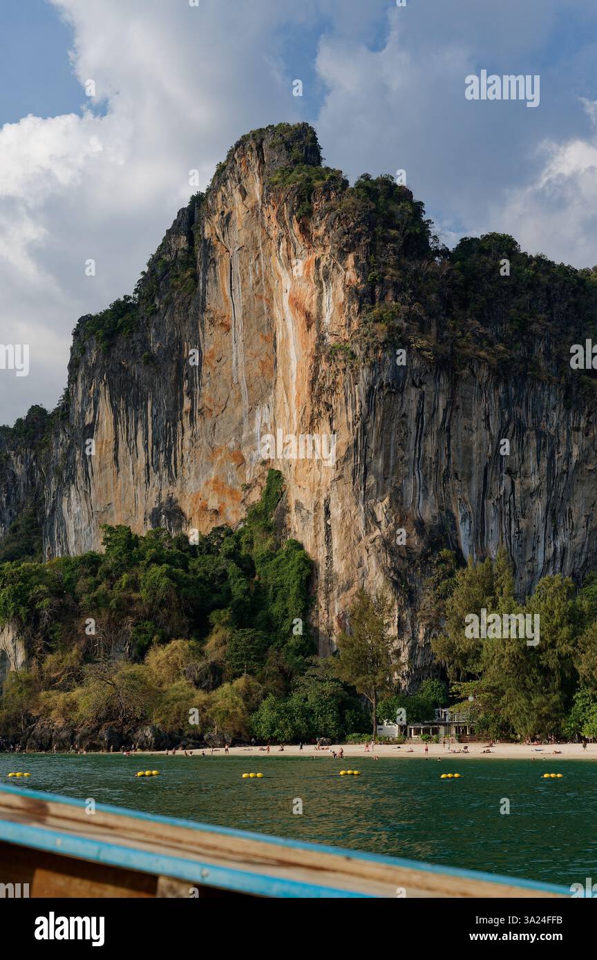 D'imposantes falaises de calcaire s'élèvent au-dessus d'une plage tropicale de Railay, encadrée par des eaux turquoises et une végétation luxuriante Banque D'Images