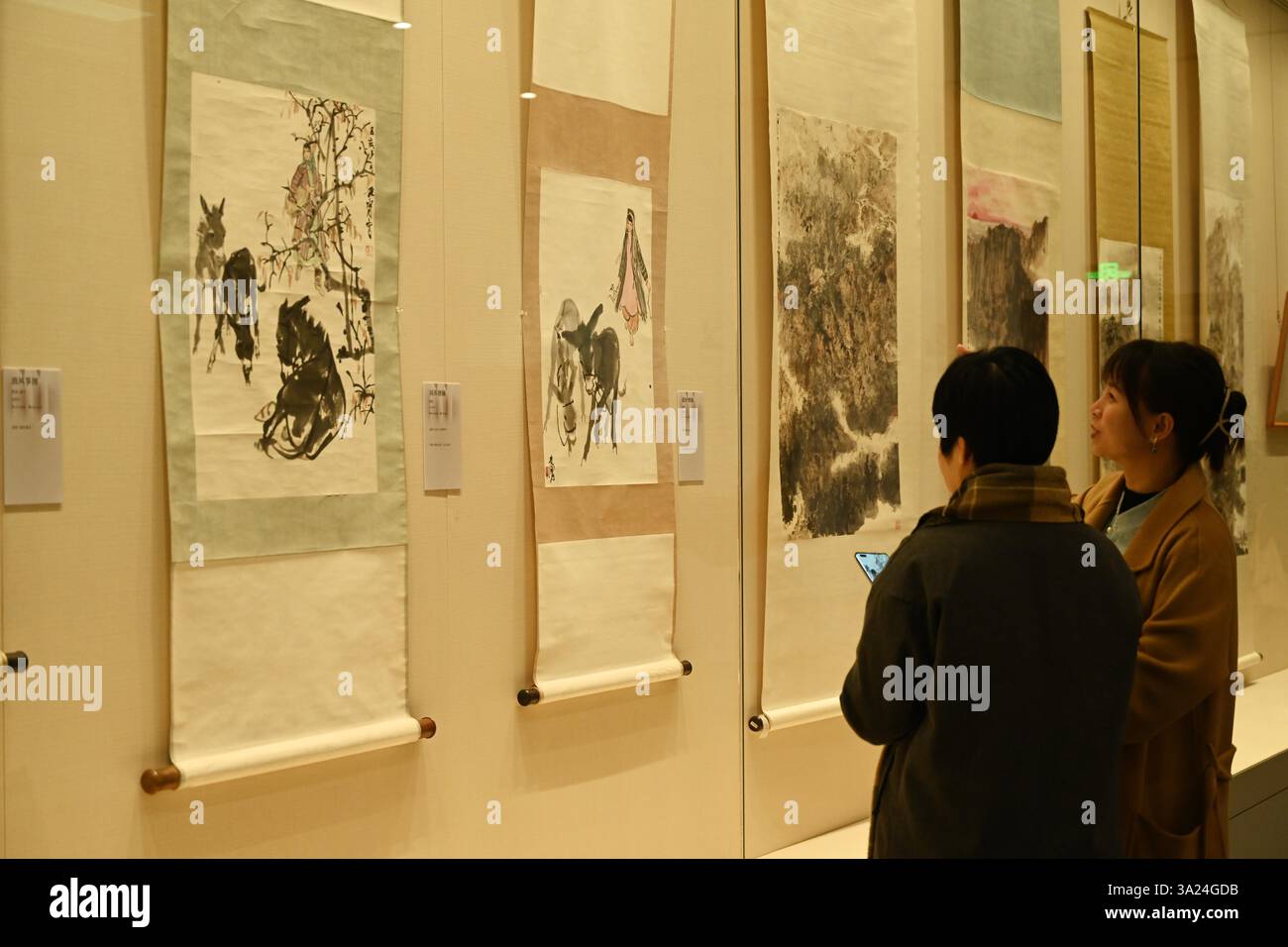 Les visiteurs regardent une exposition d'œuvres de peintres célèbres du XXe siècle à Nanning, dans la région autonome du Guangxi Zhuang, en Chine du Sud, le 11 mars 2025. Banque D'Images