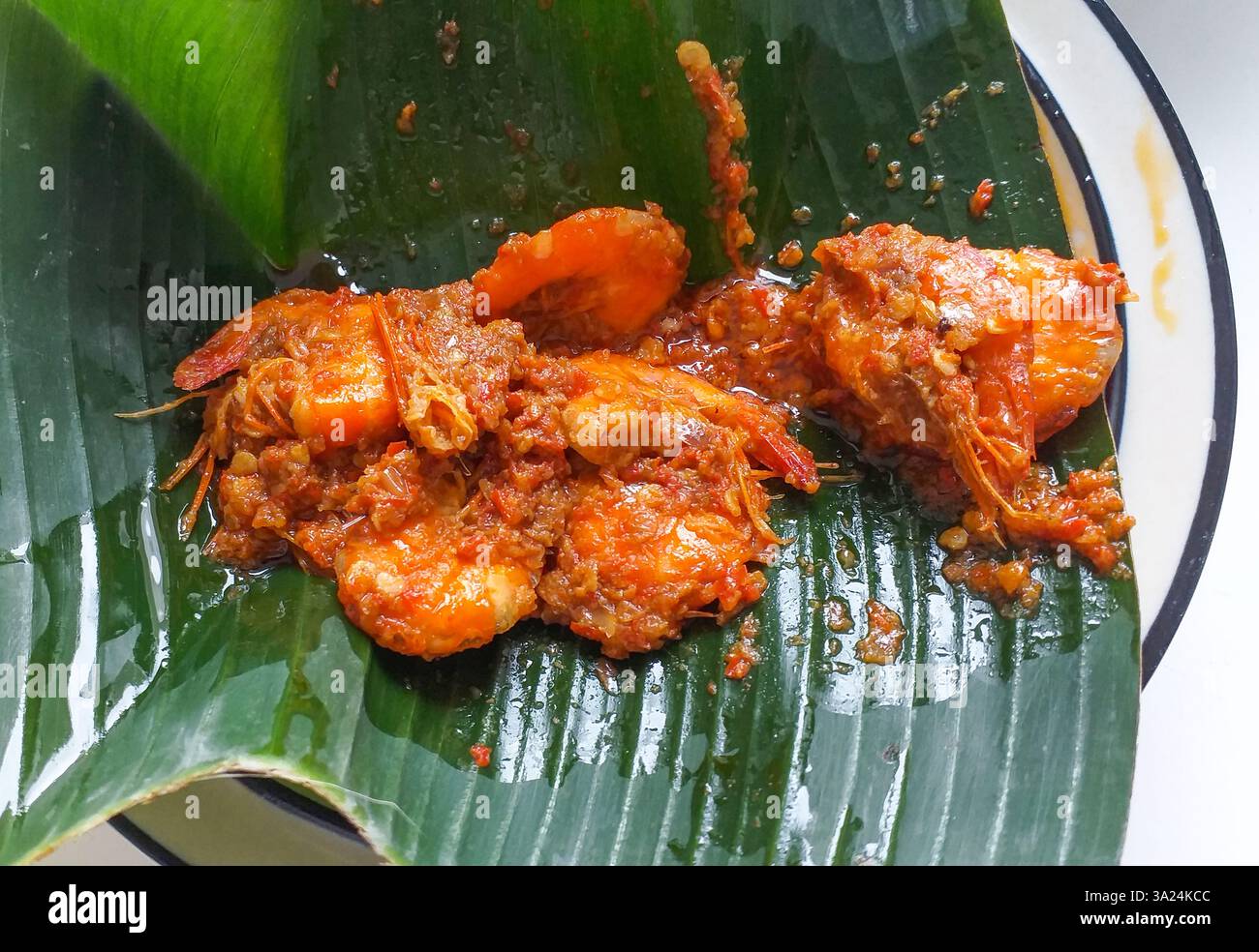 Cuisine indonésienne West Sumatra nasi padang - Udang balado qui est des crevettes frites cuites au piment rouge sambal balado avec des haricots pétai puants. Banque D'Images