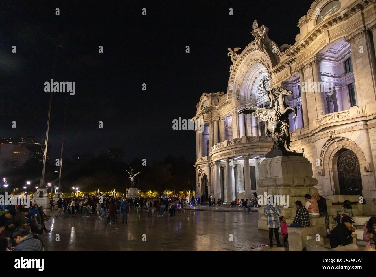 Mexico, MEXIQUE - Déc. 25 2024 : le Palacio de Bellas Artes brille sous les lumières de la nuit, avec des gens rassemblés sur la place profitant de la soirée. Banque D'Images