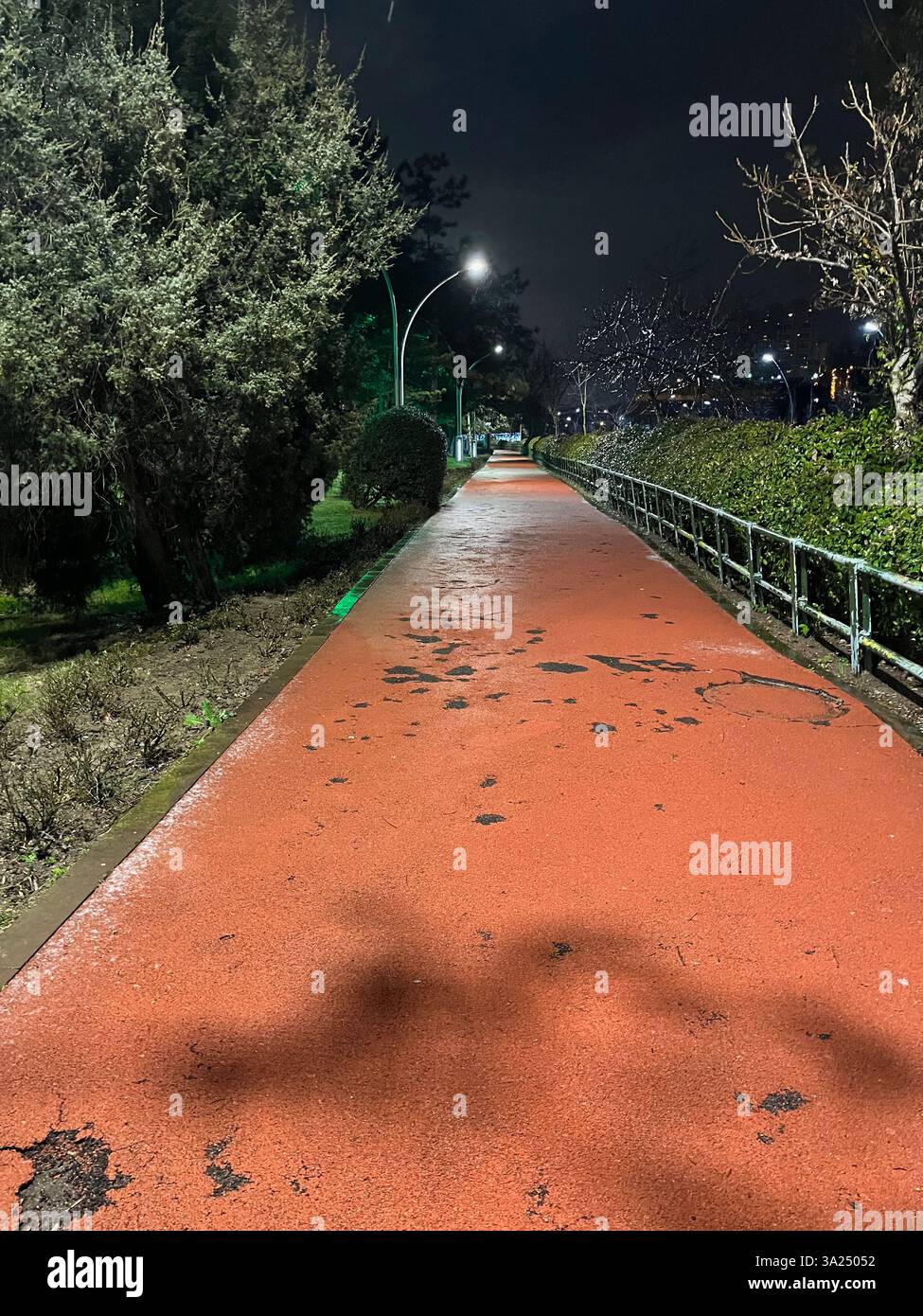 Effet de course à pied sur une piste de sport en plein air dans la nuit pluvieuse. Banque D'Images