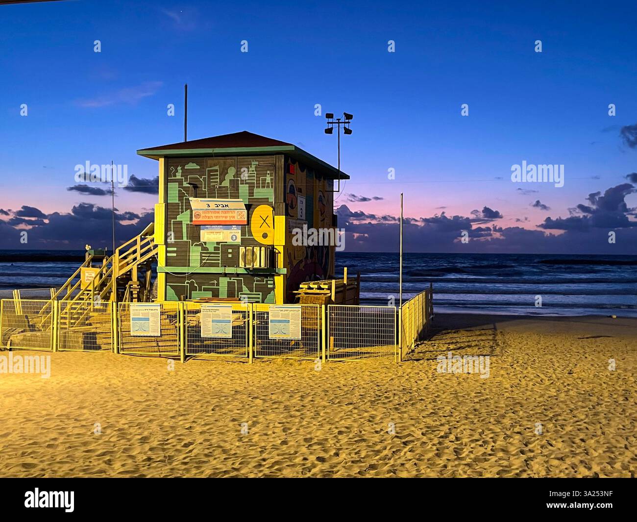 Un poste de sauveteur coloré sur une plage de tel Aviv, situé contre le ciel crépusculaire et les vagues de l'océan. Banque D'Images