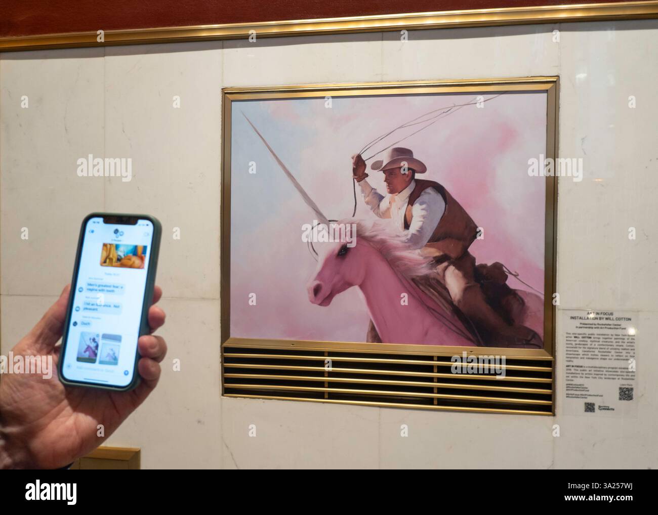 Gros plan d'un homme prenant une photo sur son iPhone du fonds de production d'art peinture par Will Cotton, 2025, Rockefeller Center, New York City, États-Unis Banque D'Images