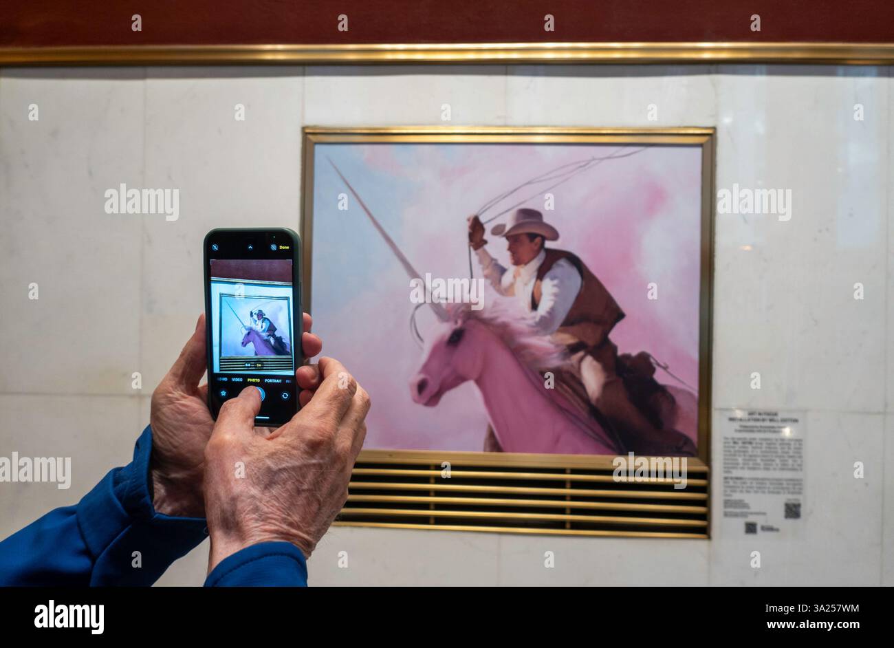 Gros plan d'un homme prenant une photo sur son iPhone du fonds de production d'art peinture par Will Cotton, 2025, Rockefeller Center, New York City, États-Unis Banque D'Images