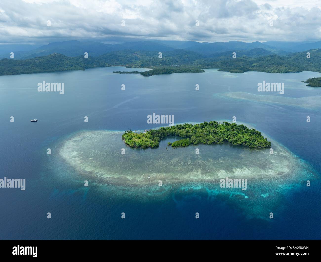 Une belle île est entourée par un récif corallien sain au large de la côte de Sulawesi Nord, Indonésie. Cette zone abrite une biodiversité marine élevée. Banque D'Images
